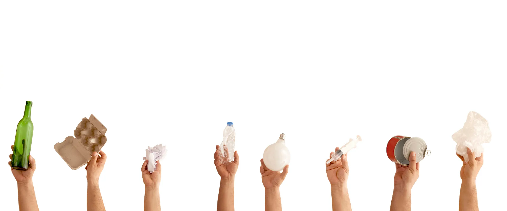 Manos que sostienen botellas, cartones y envases listos para reciclar